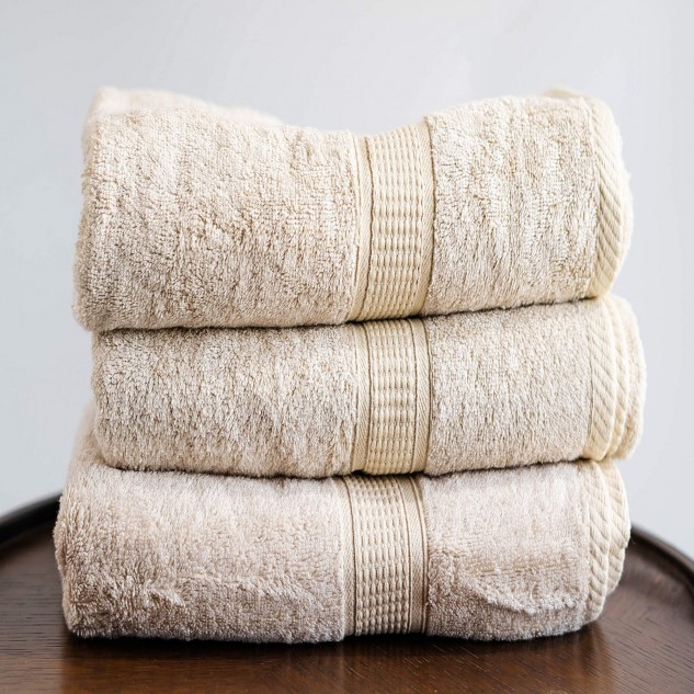 Stack of bath towels on wooden background. White and pink cotton